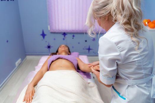 Blonde massage therapist massaging a woman. Woman getting a massage at the spa
