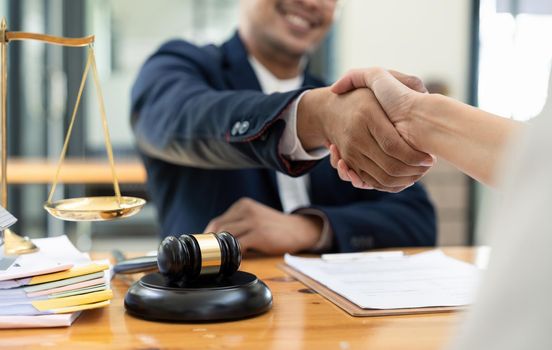 lawyer or attorneys shaking hand with client after consultation discussing a contract agreement customer at courtroom, judge service concept