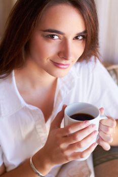 I always start my day with a fresh cup of coffee. Portrait of a young woman drinking her morning coffee.