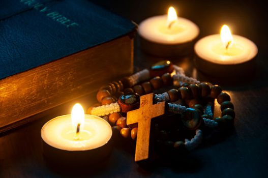 Holy Rosary, Bible and burning candles on dark background. ideas. Religion and Christianity concept.