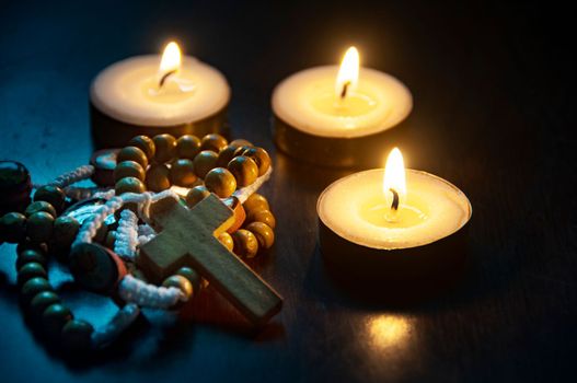 Holy Rosary and burning candles on dark background. ideas. Religion and Christianity concept.