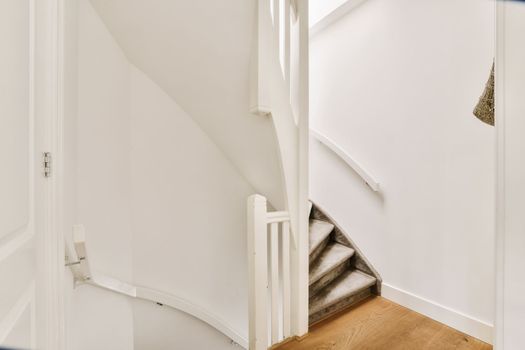 a staircase in a home with white walls and wood