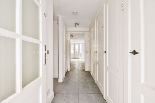 a hallway with white doors and a tiled floor