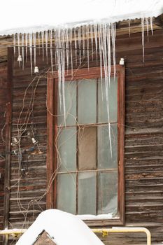 Small icicles hang on the edge of the roof, winter or spring.