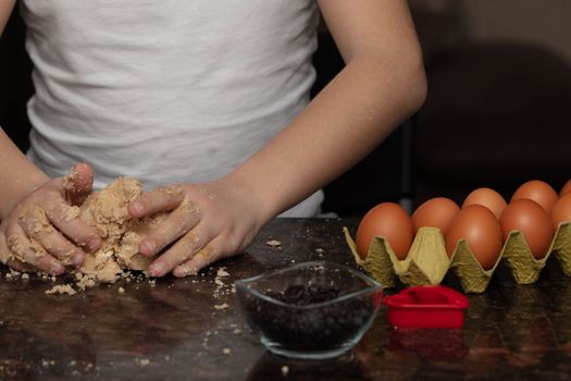 Close-up child`s hands preparing cookies