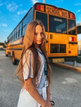 Beautiful teen girl getting on school bus