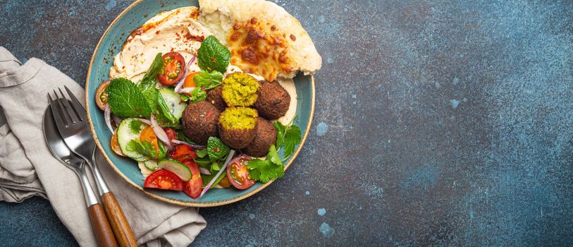 Middle Eastern Arab meal with fried falafel, hummus, vegetables salad, pita bread