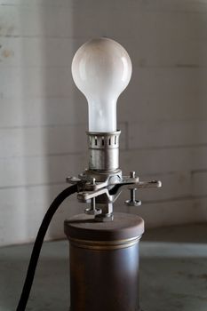 Image of Old white bulb on the vintage metal holder with power wire