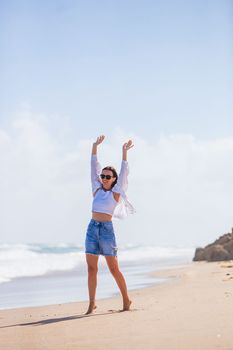 Young happy woman on the beach enjoy wind