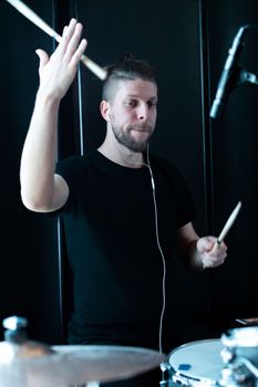 Caucasian drummer recording a drum part in a recording studio
