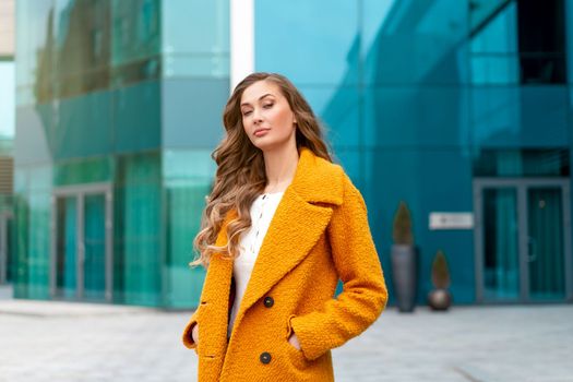 Business woman dressed yellow coat standing outdoors corporative building background