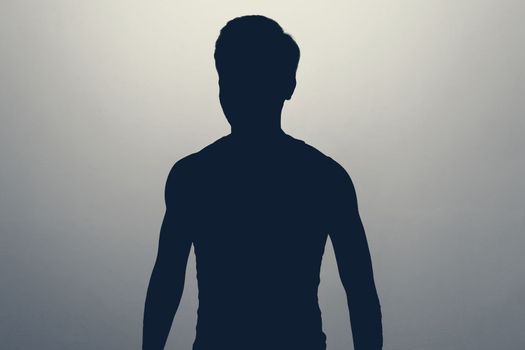 Unknown male person gray silhouette in studio. Anonymous or hidden secret.