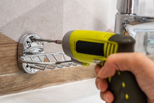 cordless screwdriver that wraps a screw into a hole in a ceramic tile