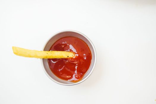 detail shot of French Fries sipping sauce on table