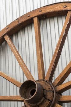 Antique wooden wheel on metallic background