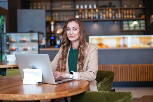 Business Woman Restaurant Owner Use Laptop In Hands Dressed Elegant Pantsuit Sitting Table In Restaurant With Bar Counter Background