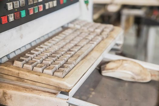 Old dirty keyboard to control a CNC machine. Focus in the foreground