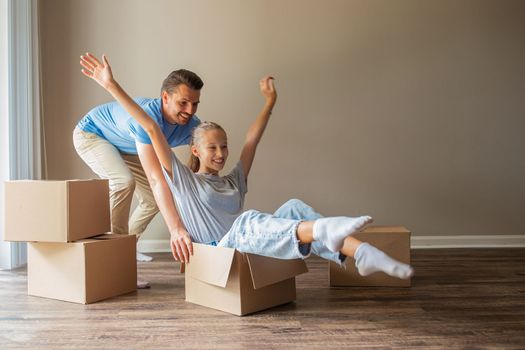 Happy family of dad and girl have fun in their new home. Family enjoy their moving day