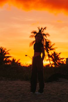 Cute teen beautiful girl on tropical seashore at sunset