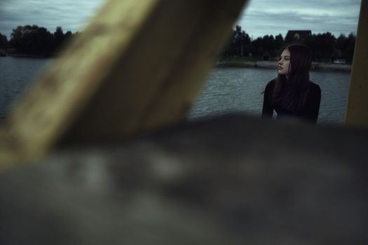 girl bullying loneliness by the water lake teenager alone in solitude trying isolation cope with anger and find strength in the evening gloomy photo abandonment thinking about fate is not easy and hard mooring at the pier