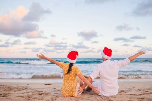 Christmas happy couple in Santa hats on beach vacation