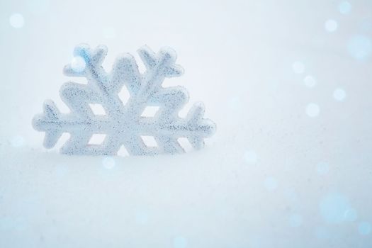 A snowflake in the snow. Christmas background with decorative snowflake on snow