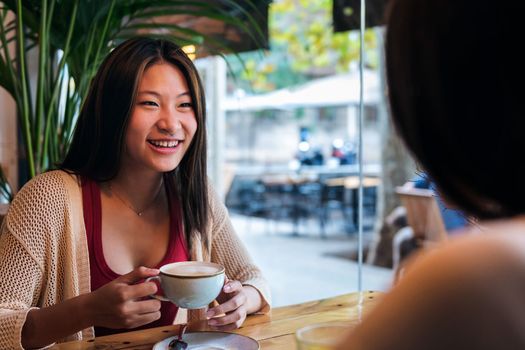 smiling woman in a coffee shop with a friend