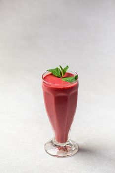 Glass of fresh berry smoothie with mint