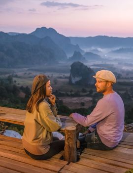 A couple watching the Sunrise with fog at Phu Langka in Northern Thailand, Phu Langka National Park