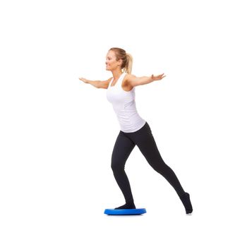 Balance is key. Full length studio shot of a woman doing balance exercises isolated on white.