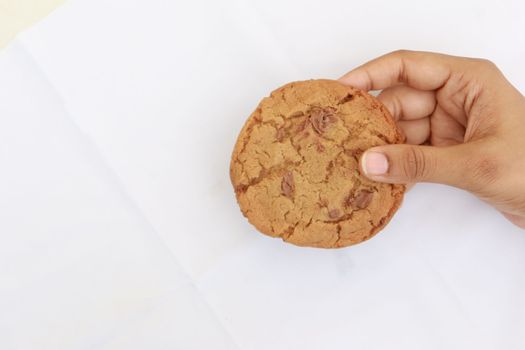 overhead view of holding chocolate sweet cookies on white background 