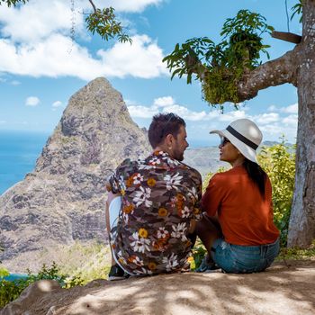 couple hiking in mountains Saint Lucia Caribbean, nature trail in jungle with view of huge Pitons