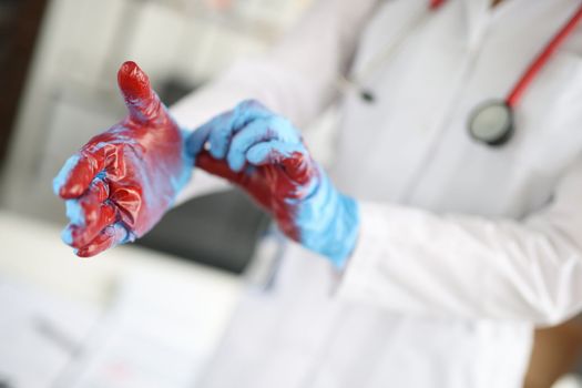 Closeup of hands of surgeon in blood after operation