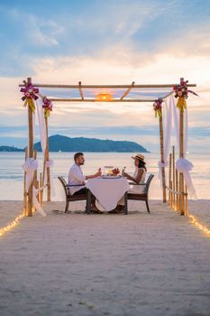 Romantic dinner on the beach in Phuket Thailand, couple man and woman having dinner on the beach 