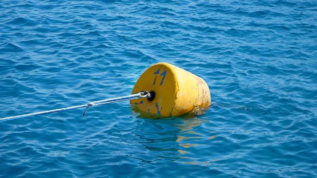 summer, sea, in transparent bluish water floats orange buoy