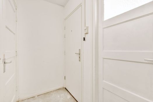 an empty room with white doors and a window