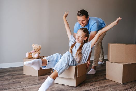 Happy family of dad and girl have fun in their new home. Family enjoy their moving day