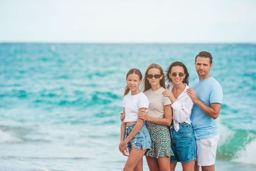 Happy family posing on the beach during summer vacation