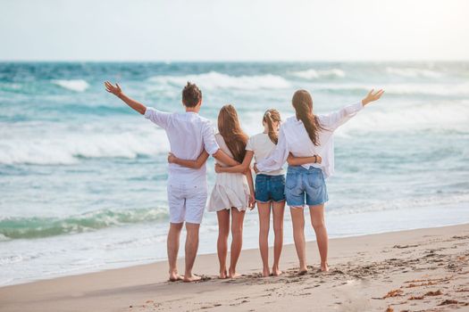 Happy family of four on the beach at summer vacation