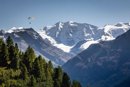 Paragliding above Bernina mountain range with glaciers in the Alps, Switzerland