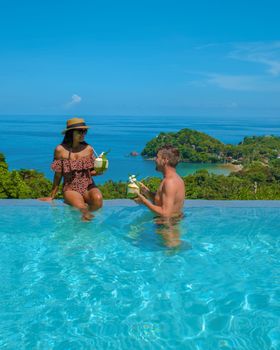 couple in infinity pool in Thailand looking out over the ocean, luxury vacation in Thailand