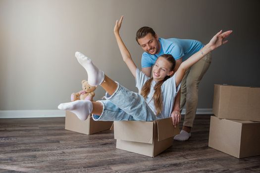 Happy father with daughter have fun in their new home. Family enjoy their moving day
