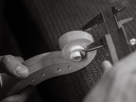 luthier precision measuring the violin scroll thickness with meter