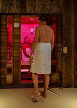 couple in sauna, men and woman in bathrobe visiting a hot infrared sauna