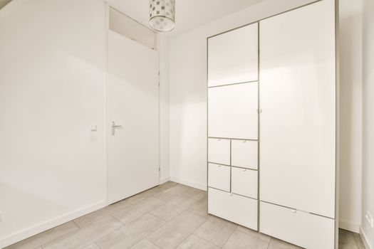 a room with white closets and a tile floor