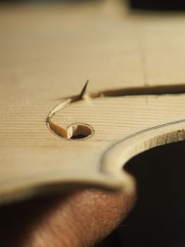 luthier cutting and shaping violin f - hole