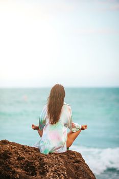 Young woman with practicing yoga on the beach