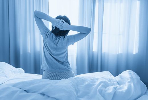 Woman stretching in bed after wake up, with copy space