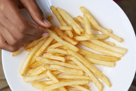 top view of hand pick french Fries on table 