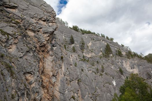A large mountain with a sheer cliff close-up against the sky. 